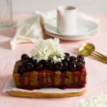 Finished loaf cake with cherries and flowers on top.
