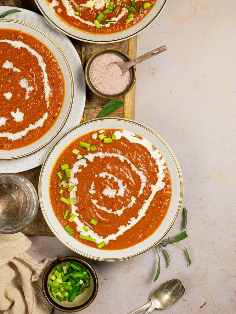 three bowls of soup on a board being served. 