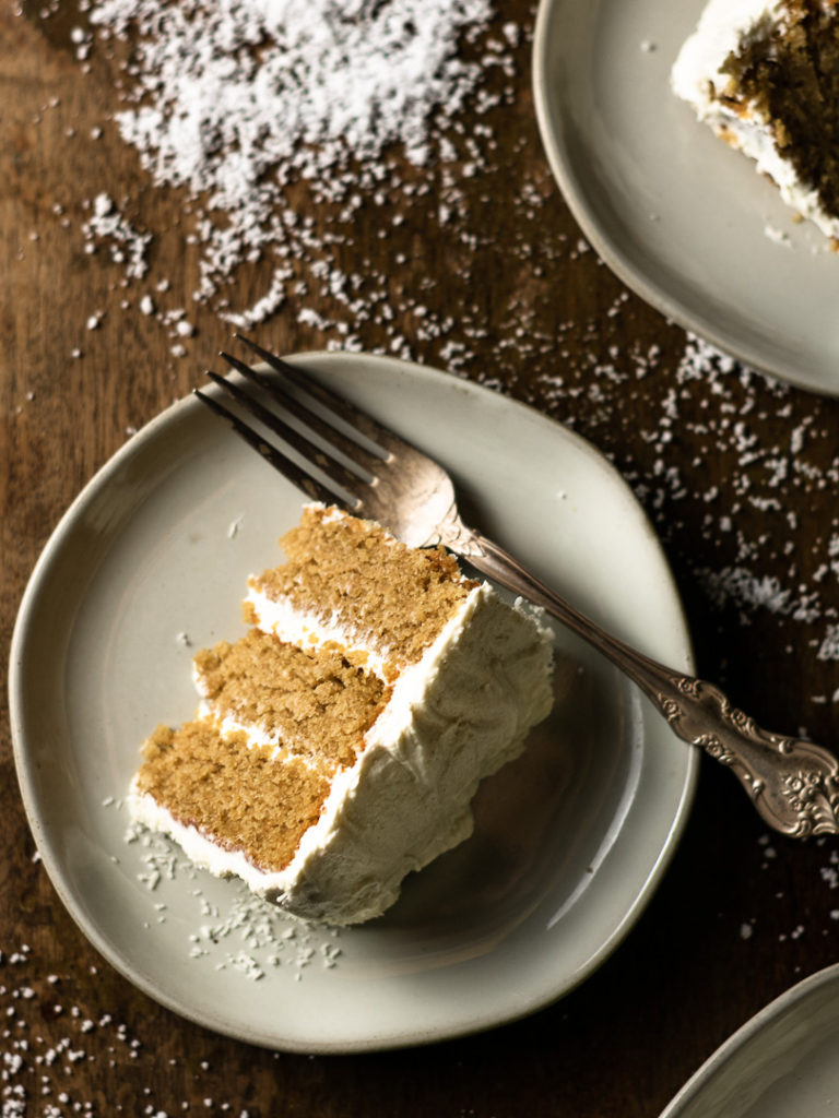 Slices of vegan coconut cake with creamy frosting layers.