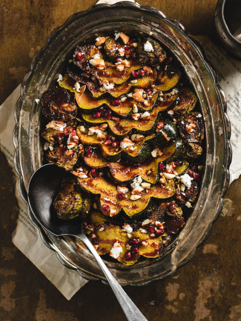 A beautiful dish of festive squash and roasted brussels finished with vegan feta cheese.  