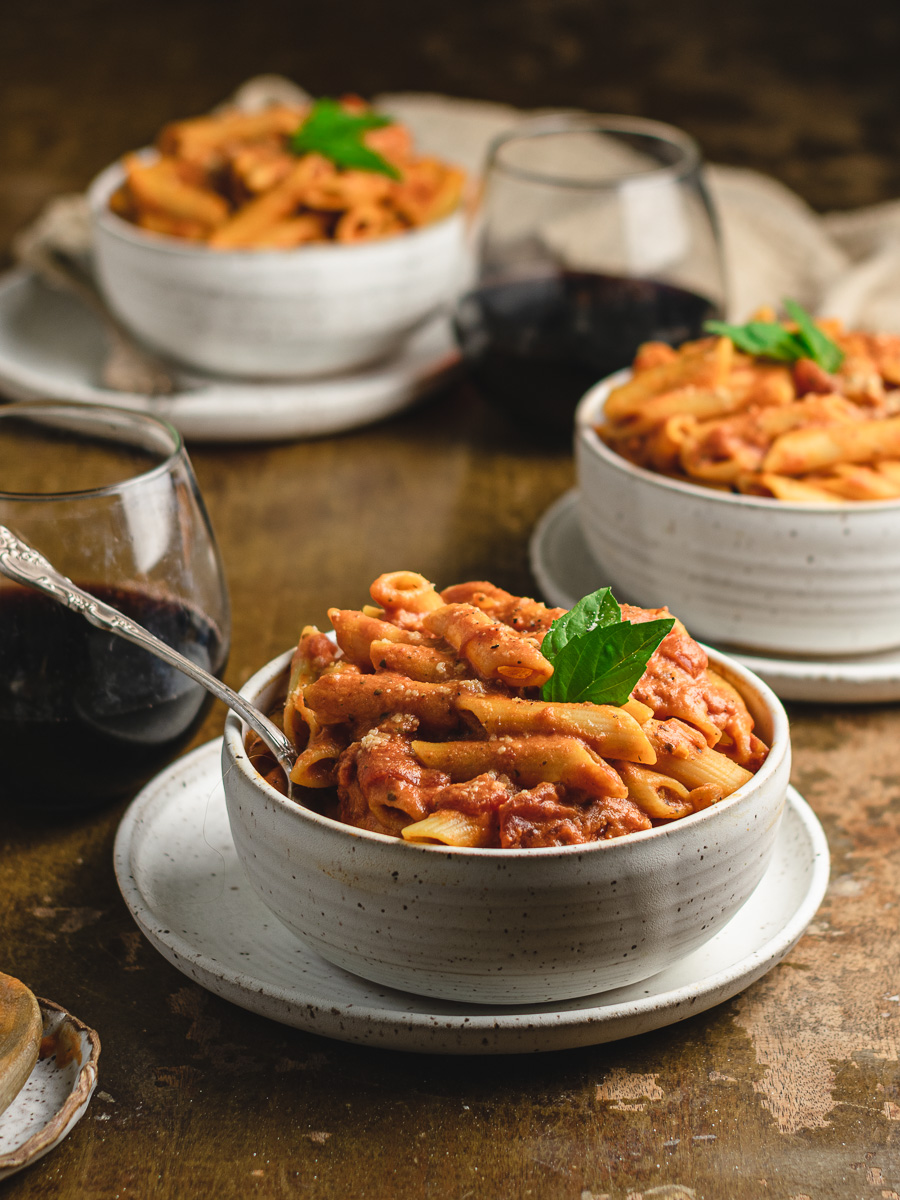 Table with pasta bowls and red wine