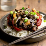 big bowl of white rice with eggplant and cahsews