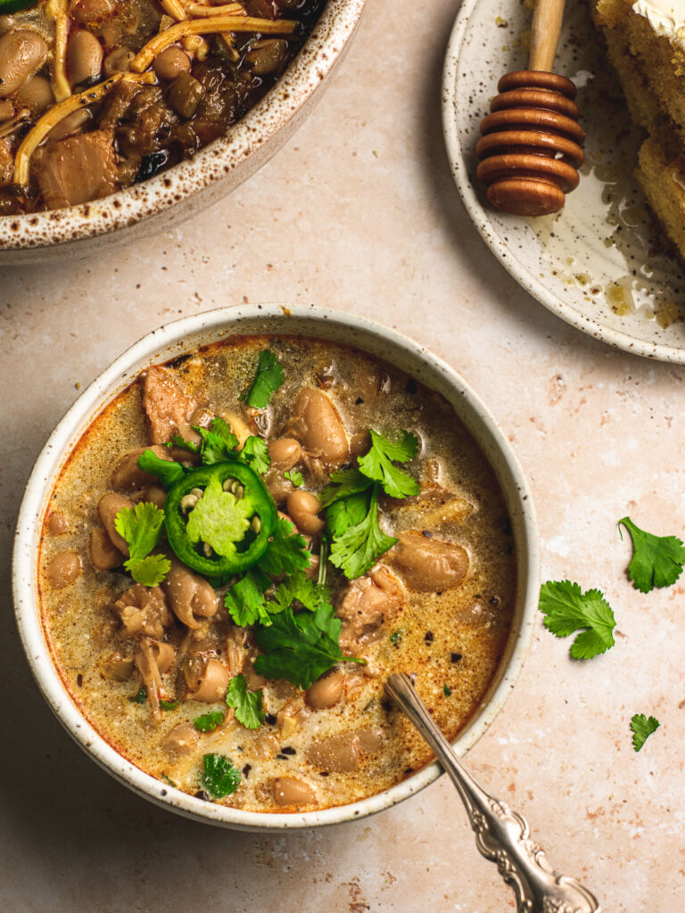 Big bowl of white chili with jalapenos and cornbread. 