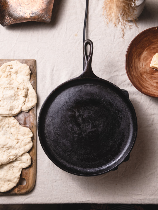 showing how to preheat a cast iron skillet and make flatbread 